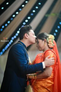 Husband kisses on wife's forehead.