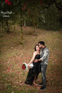 Boy is kissing on girl's face and girl is holding a flower booket