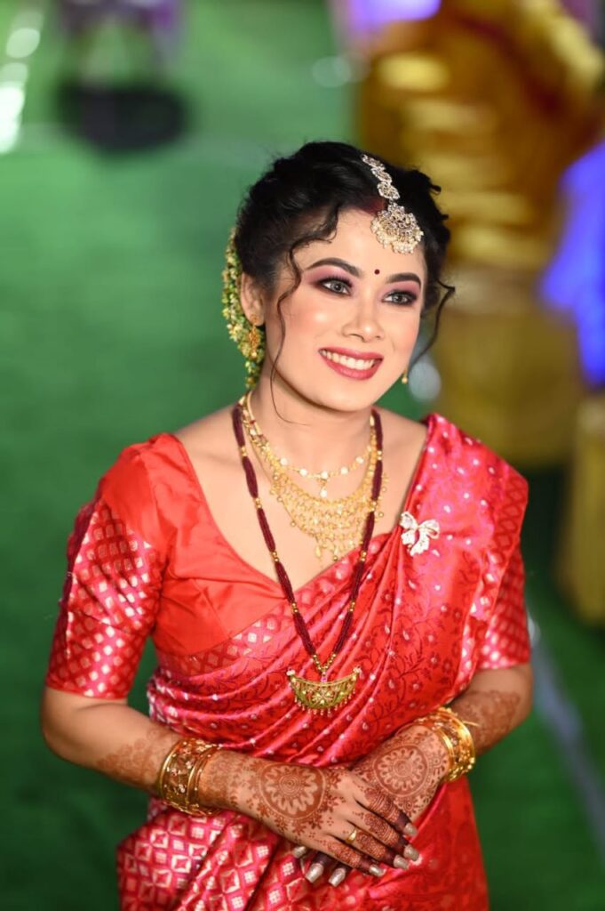 Assamese girl wearing a mekhela chador, smiling happily.