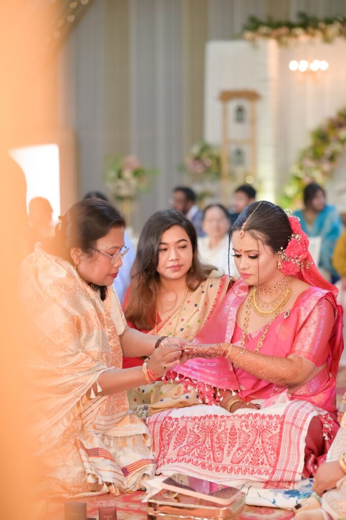 Woman adorning the bride with a ring.