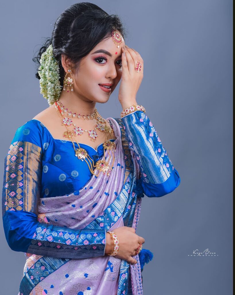 Girl striking a pose wearing a blue mekhela chador.