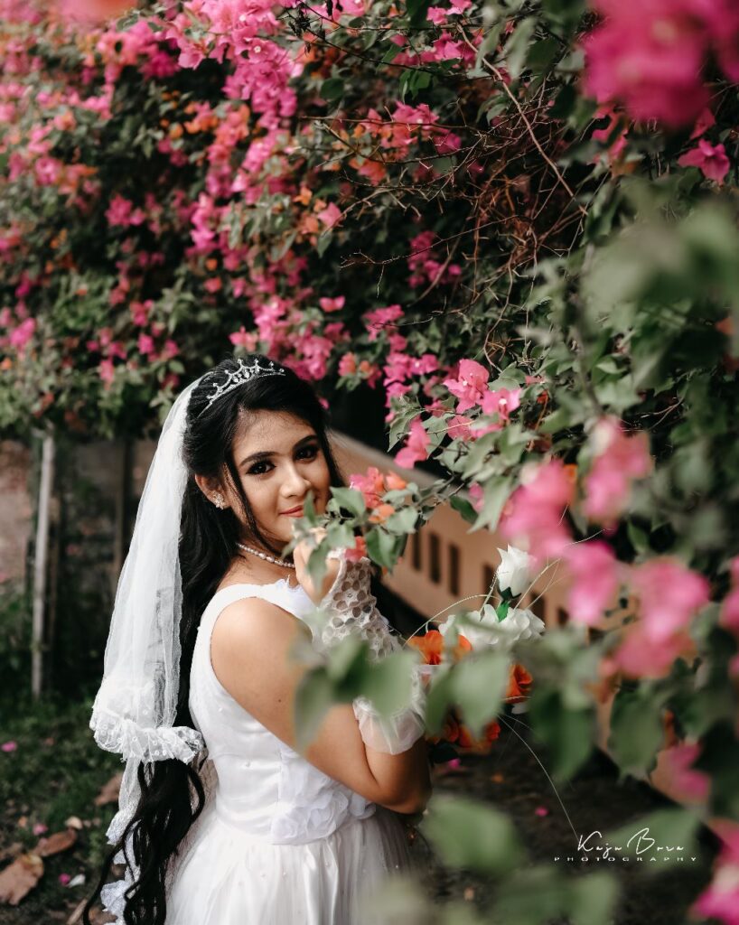 Bride striking a pose while holding a flower in her hand.