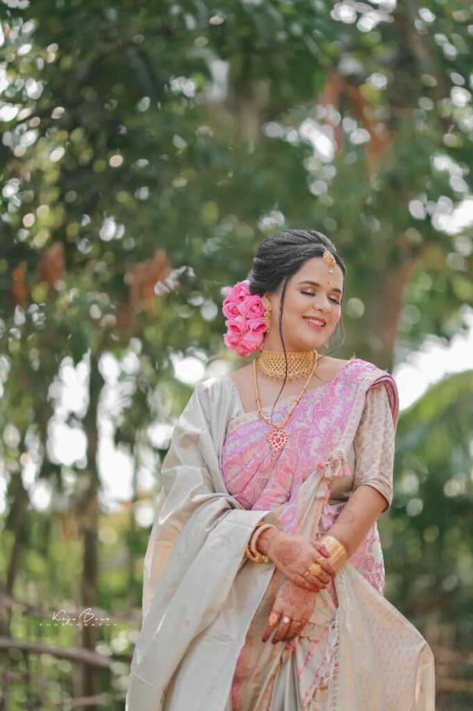 A smiling girl wearing a mekhela chador in traditional style.
