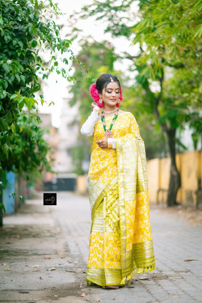 Assamese girl wearing a yellow mekhela chador.