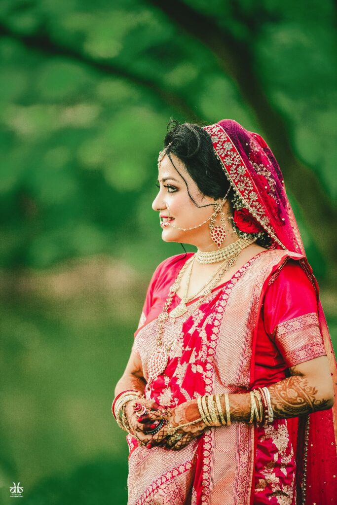 Bride is smiling in a red sari.