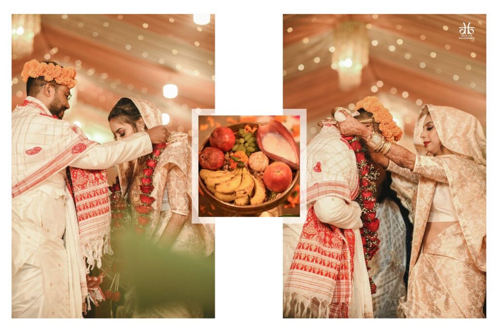 Groom and bride exchanging garlands around each other's necks.