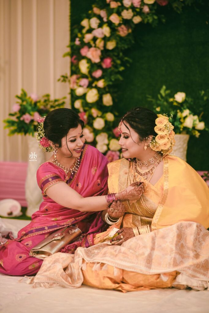 A woman adjusting another woman's necklace.