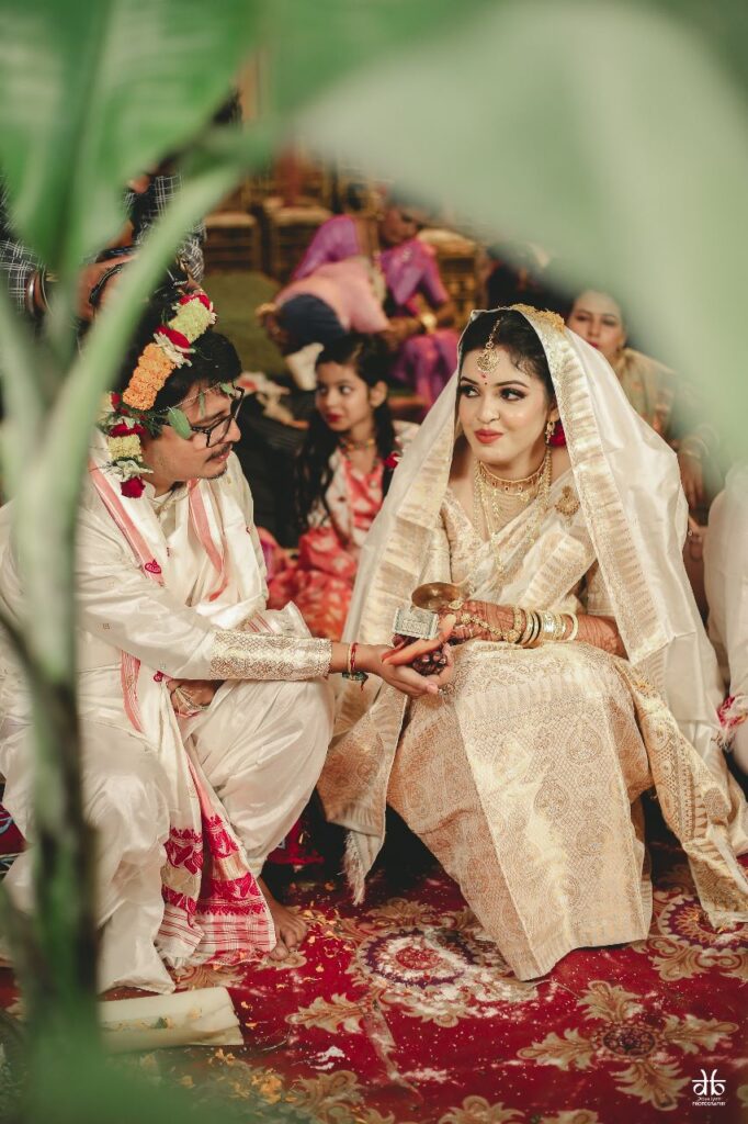 Bride and groom seated on the ground.