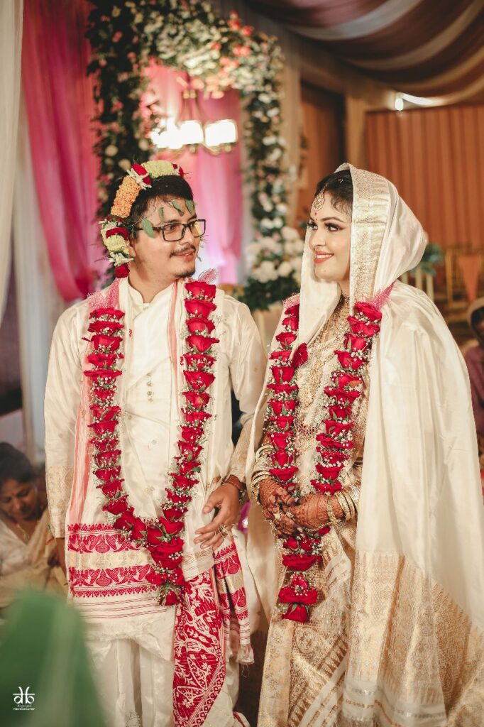 Bride and groom exchange their smiles while looking at each other.