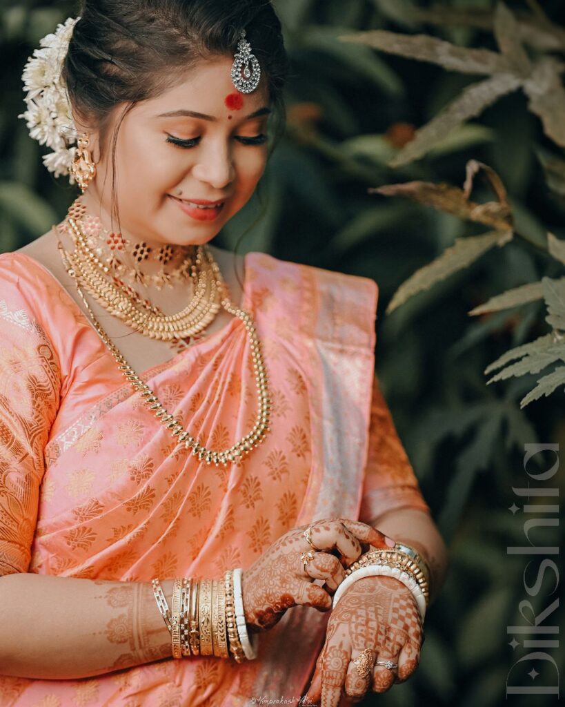 The girl is smiling and looking at her bangles.