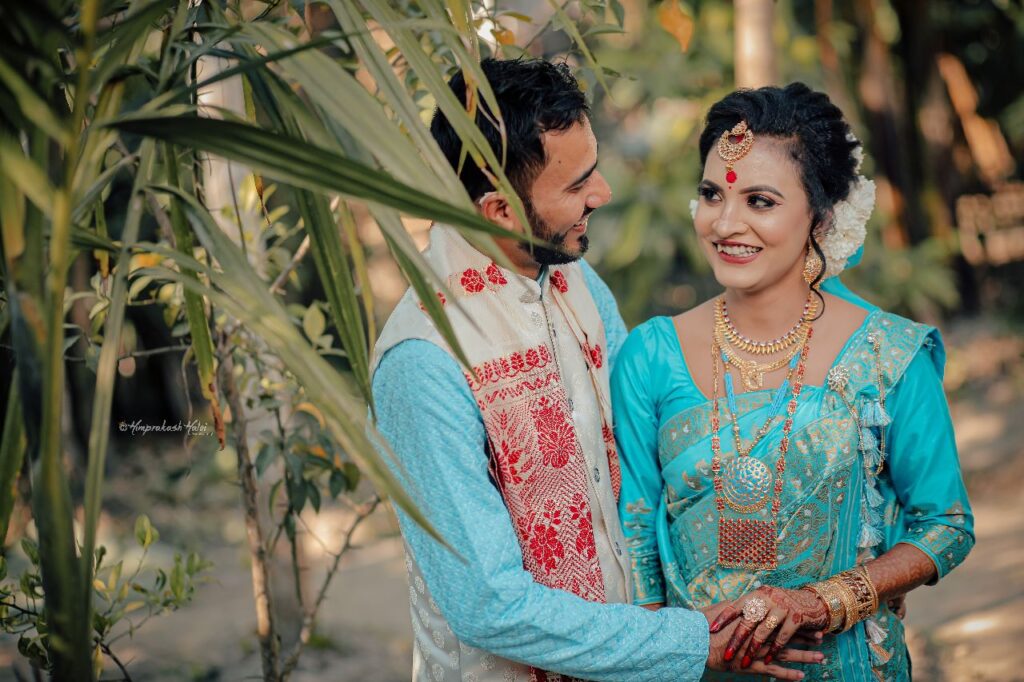 Smiling bride and groom in a blue attire.