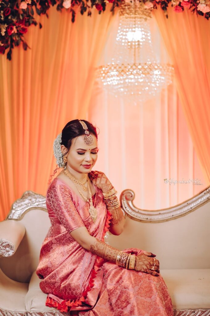 A bride sitting on a sofa, admiring her mehndi design.