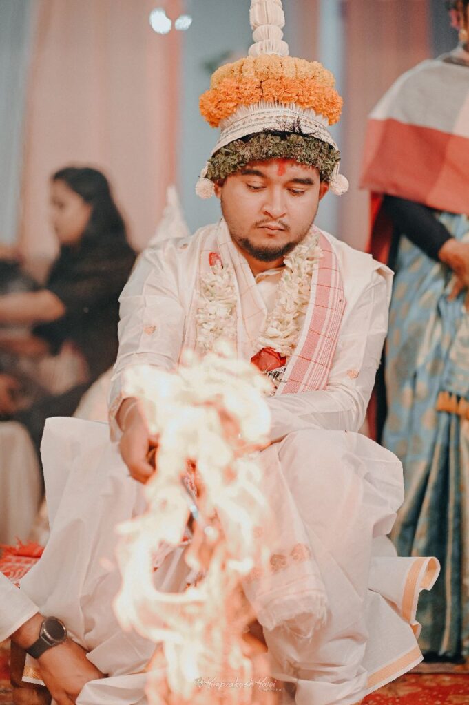 Groom seated in front of the wedding mandap.