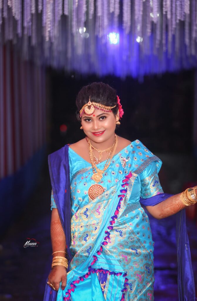 A smiling girl wearing a mekhela chador in traditional style.
