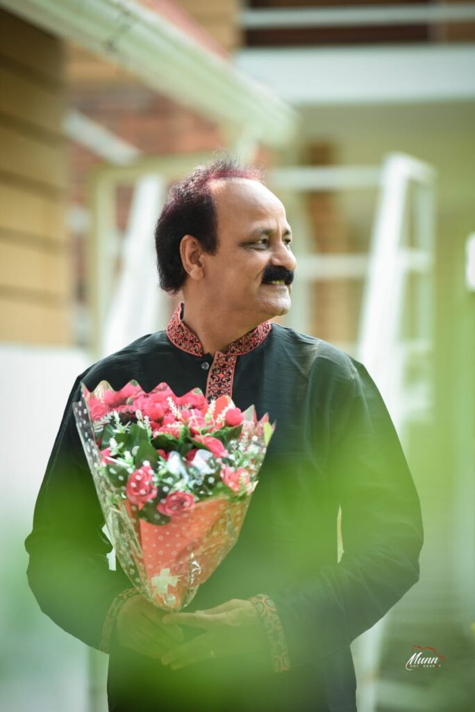 A smiling man holding flower bucket in her hand.