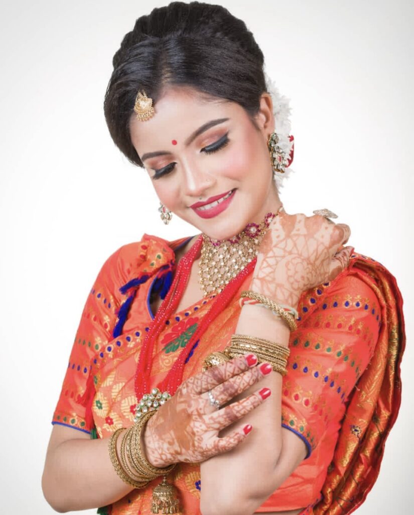 Assamese smiling girl looking her bangles.