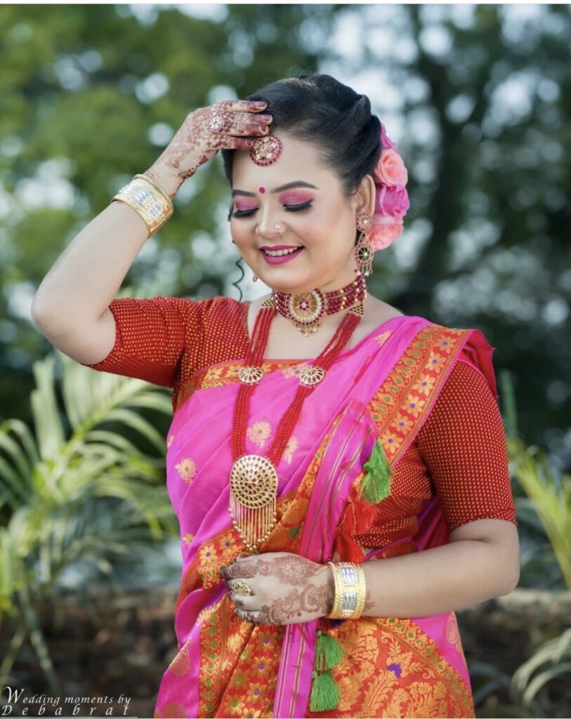 Assamese girl wearing mekhela chador attire with a well-applied makeup.