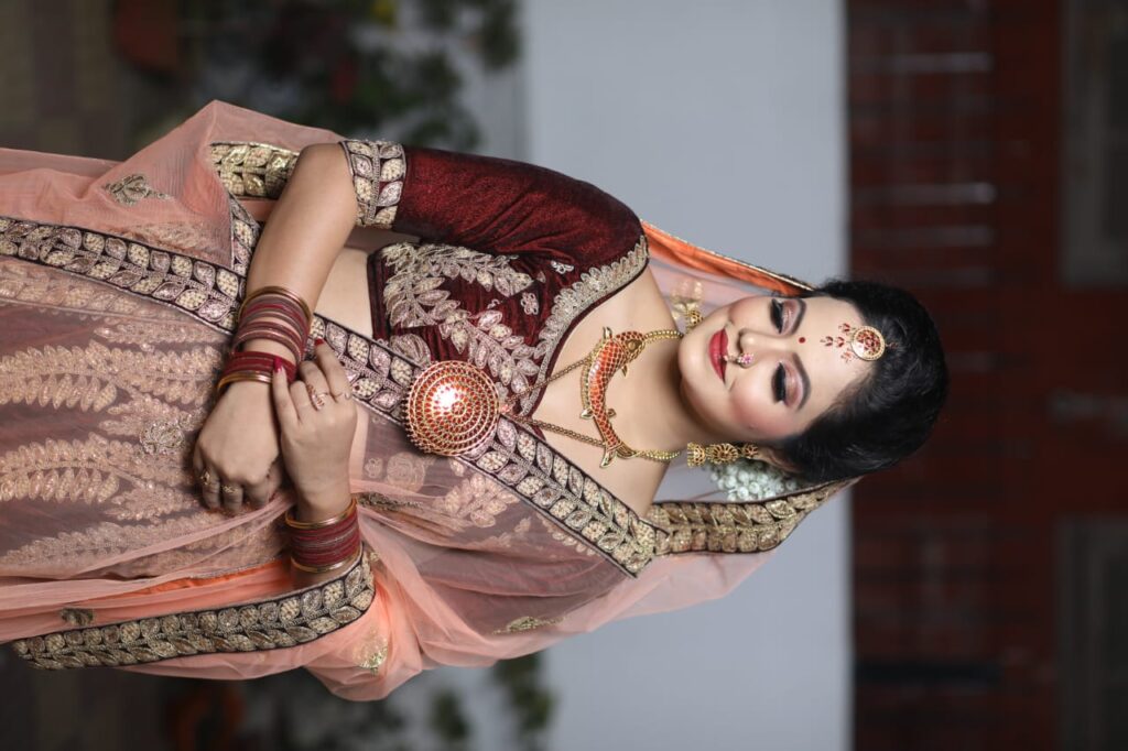 A smiling girl wearing a mekhela chador and looking downwards