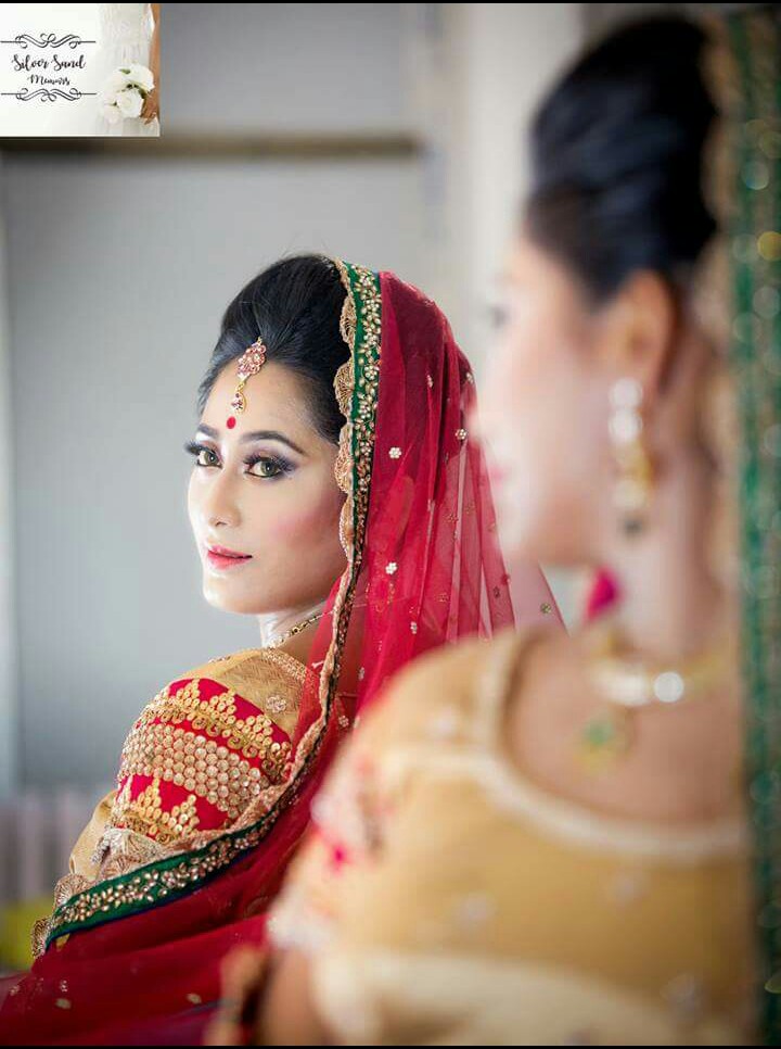 Bride looking at herself in the mirror, with her back turned.