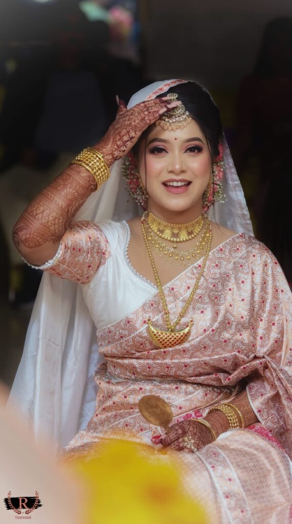 Bride happily smiling while holding her teeka.