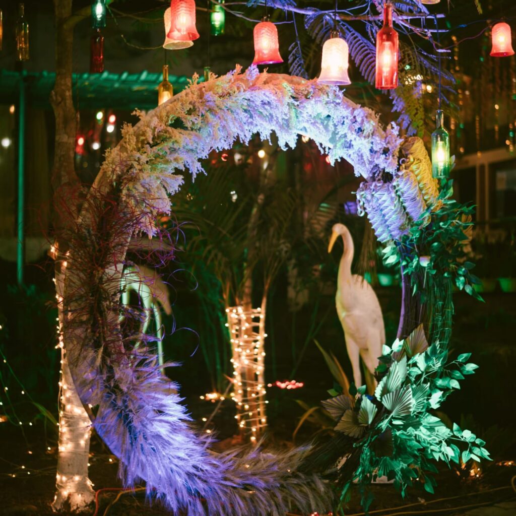 A fake duck is seated among decorative elements with lights hanging over it.
