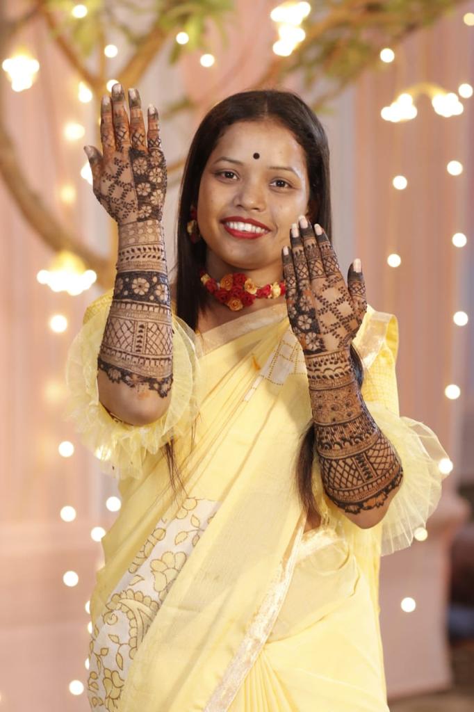 Assamese girl showing her hands adorned by mehndi.