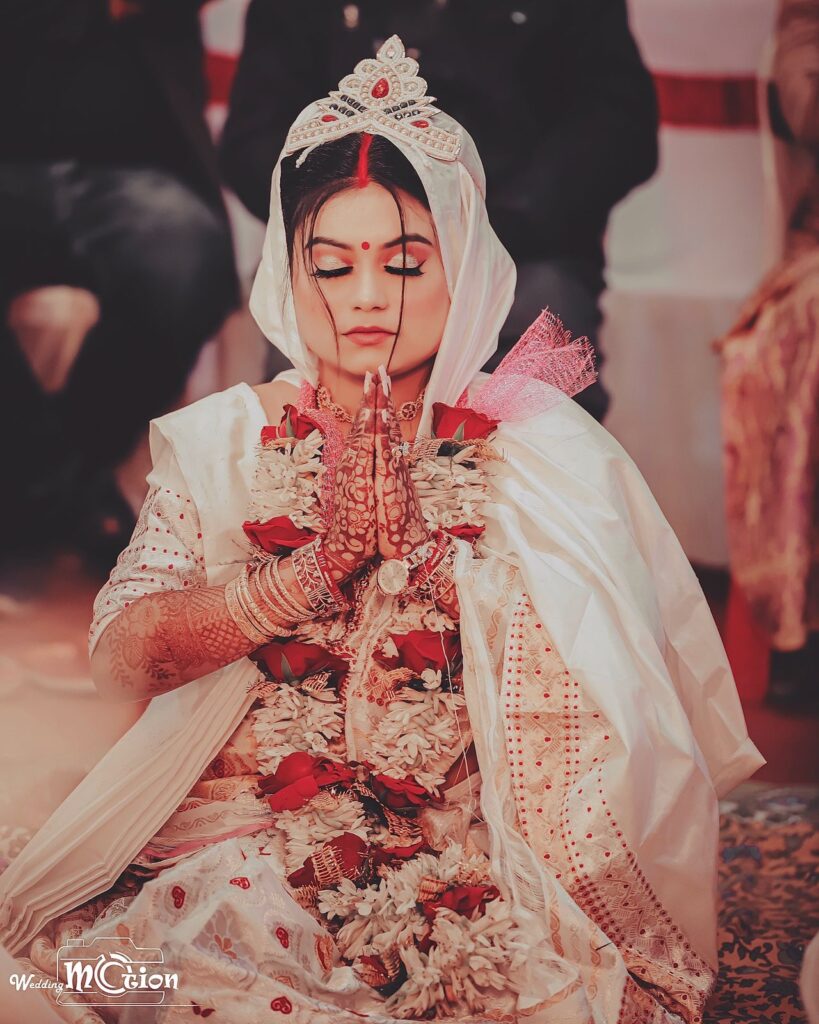 A girl performing a prayer ritual in the mandap.